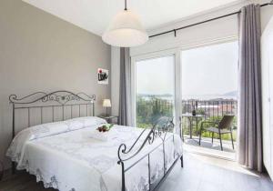 韦尔巴尼亚B&B Stella Maggiore的白色的卧室设有床和大窗户
