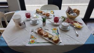 佩萨罗佩蒂卡利酒店的一张带食物和饮料的白色桌子