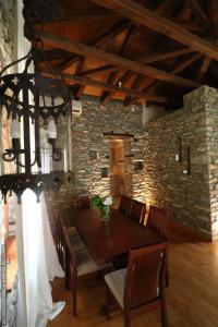 阿吉奥斯伊欧尼斯House Smaragdi的一间设有木桌和石墙的用餐室