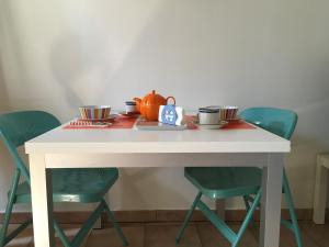 米兰洛迪庄园公寓的一张桌子,上面有四把椅子和茶壶