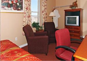 巴尔的摩中城酒店的酒店客房带一张床、一台电视和椅子
