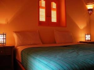 卢克索villa al diwan luxor的一间卧室配有一张带蓝色床单的床和两个窗户。