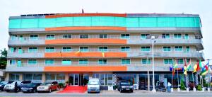 科托努Nobila Airport Hotel的前面有汽车停放的建筑