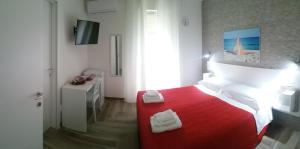 圣维托诺曼La Bella Vita的一间卧室配有红色的床和毛巾