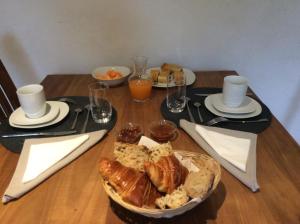 普卢伊内克Domaine de Tréouzien的一张桌子,上面放着一盘面包和一杯橙汁