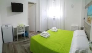 圣维托诺曼La Bella Vita的一间卧室配有一张绿色的床和一张书桌