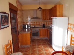VillamaleaCasa La Abuela的厨房配有木制橱柜和白色冰箱。