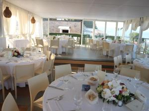 迪亚诺马里纳波焦代格力农家乐的用餐室配有白色的桌子和白色的椅子