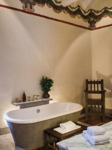 库斯科因卡特拉拉卡索纳罗莱夏朵酒店的带浴缸的浴室和椅子
