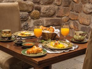 库斯科因卡特拉拉卡索纳罗莱夏朵酒店的餐桌,带食物盘和橙汁杯