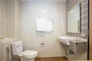 合艾禅南公寓公寓式酒店的一间带卫生间、水槽和镜子的浴室