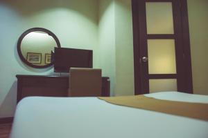 碧瑶碧瑶 - 埃尔西利图酒店的客房设有镜子、一张床和一张书桌