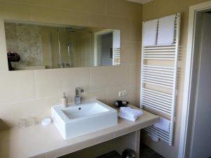 布隆Hotel Seeblick Garni的浴室设有白色水槽和镜子