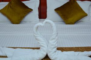 尼兹瓦奥卡拉姆酒店的两个天鹅在床上心跳