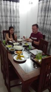 尼甘布Ahasna Family Villa的坐在餐桌旁吃饭的男人和女人