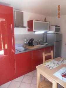 布里昂松Le chalet的一间设有红色橱柜和一张桌子的小厨房