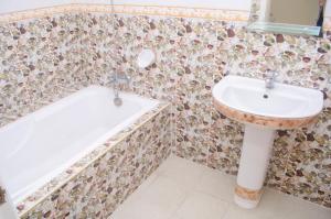 奥隆阿波朱丽斯热带公寓的浴室配有盥洗盆和浴缸。