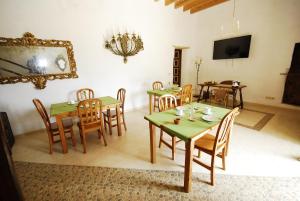阿尔塔Finca Sa Duaia de Dalt的用餐室配有绿色桌子和木椅
