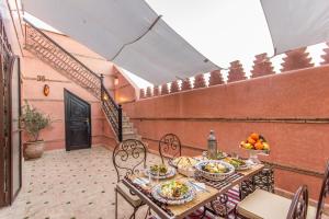 马拉喀什马拉喀什拉米亚摩洛哥传统庭院住宅的阳台上摆放着食物盘的桌子