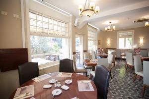 海法克罗尼酒店的餐厅设有桌椅和大窗户。