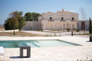 马泰拉Masseria Fontana di Vite的一座游泳池,其建筑背景为: