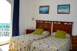 多列毛利诺斯普拉萨玛尔公寓的一间卧室配有两张带绿色枕头的床