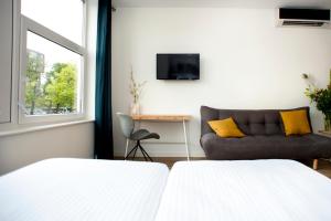 阿姆斯特丹I汽车旅馆的一间带两张床和一张沙发的客厅