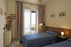 吉法Residence Roccolo的一间卧室设有两张床和大窗户