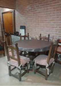 圣萨尔瓦多德朱Cabaña San Pablo的一张桌子,上面有四把椅子和砖墙