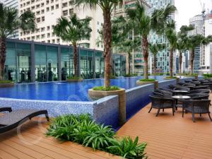 吉隆坡靠近KLCC/吉隆坡市中心5星级豪华公寓的一座带椅子和棕榈树的游泳池