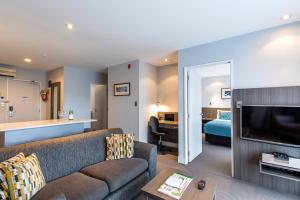 奥克兰奎斯特新市场服务式公寓的客厅配有沙发和1张床