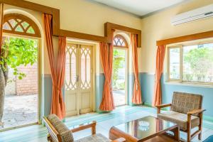 焦特布尔季节酒店的客厅配有橙色窗帘和桌椅