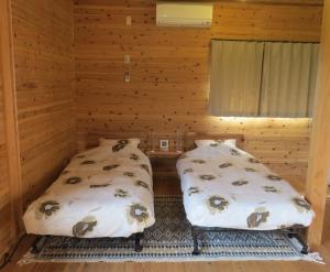 屋久岛屋久岛橙色小屋的小木屋内带两张床的房间