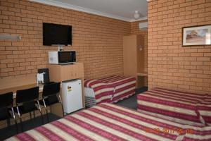 吉尔甘德拉Cooee Motel的客房设有两张床和一台平面电视。