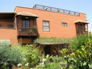 圣米格尔德阿沃纳Hotel Rural San Miguel - Only Adults的庭院里一座带窗户和植物的橙色房子
