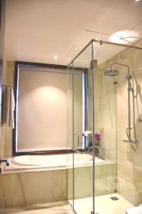 胡志明市标志精品酒店的浴室里设有玻璃门淋浴