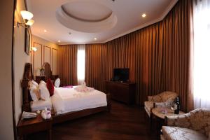 Thanh Bình安禄酒店及Spa的一间卧室配有一张床、一张沙发和一台电视。