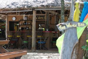 Tha Lane BayMelina Beach Front Bungalows的餐厅设有酒吧,配有桌椅