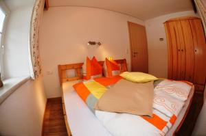 瑟弗浩斯Bauernhof Gfraser的一间卧室配有一张带橙色和黄色枕头的大床