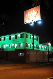 累西腓Eros Hotel CDU (Adults Only)的建筑物在晚上被绿色点亮