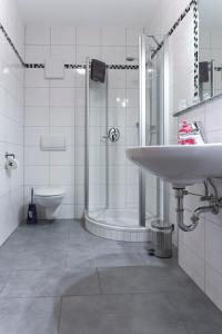 TittlingLandgasthof Schmalhofer的一间带水槽、淋浴和卫生间的浴室