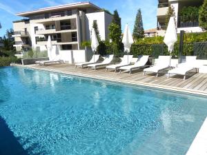 圣特罗佩Luxury & Exclusive Resort的一座带躺椅的游泳池和一座建筑