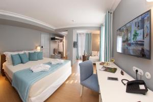 阿尔戈斯托利翁阿尼诺斯酒店的酒店客房设有一张大床和一张书桌。
