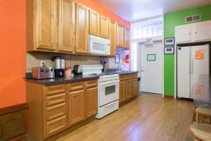 芝加哥Wrigley Hostel - Chicago的厨房配有木制橱柜和白色家电