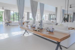 塔拉曼卡Destino Pacha Ibiza的客厅配有白色家具和木桌