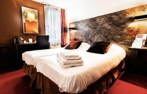 隆勒索涅隆勒索涅乐吉斯酒店 - 烧烤餐厅的酒店客房,配有带毛巾的床