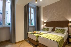 罗马纳沃纳精品酒店的一间酒店客房,房间内设有两张床