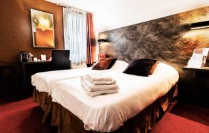 隆勒索涅隆勒索涅乐吉斯酒店 - 烧烤餐厅的酒店客房,配有带毛巾的床