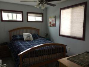 麋鹿城Eycat Lodging Company Guest House的一间卧室配有一张床和吊扇