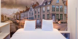 布鲁日马塞乐酒店的一张床位,房间享有城市景